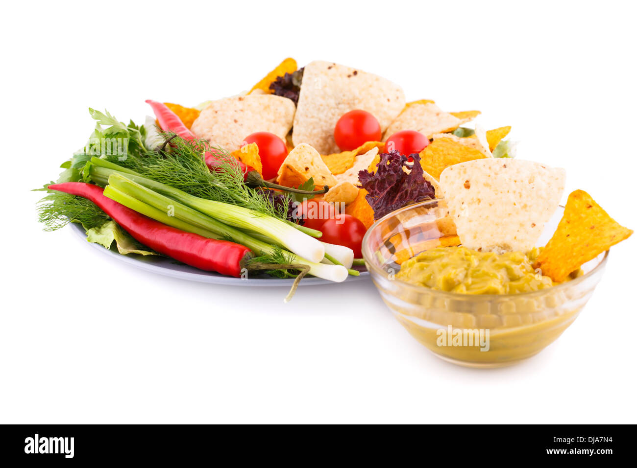Nachos, cherry tomatoes, lettuce, herbs in plate on white background