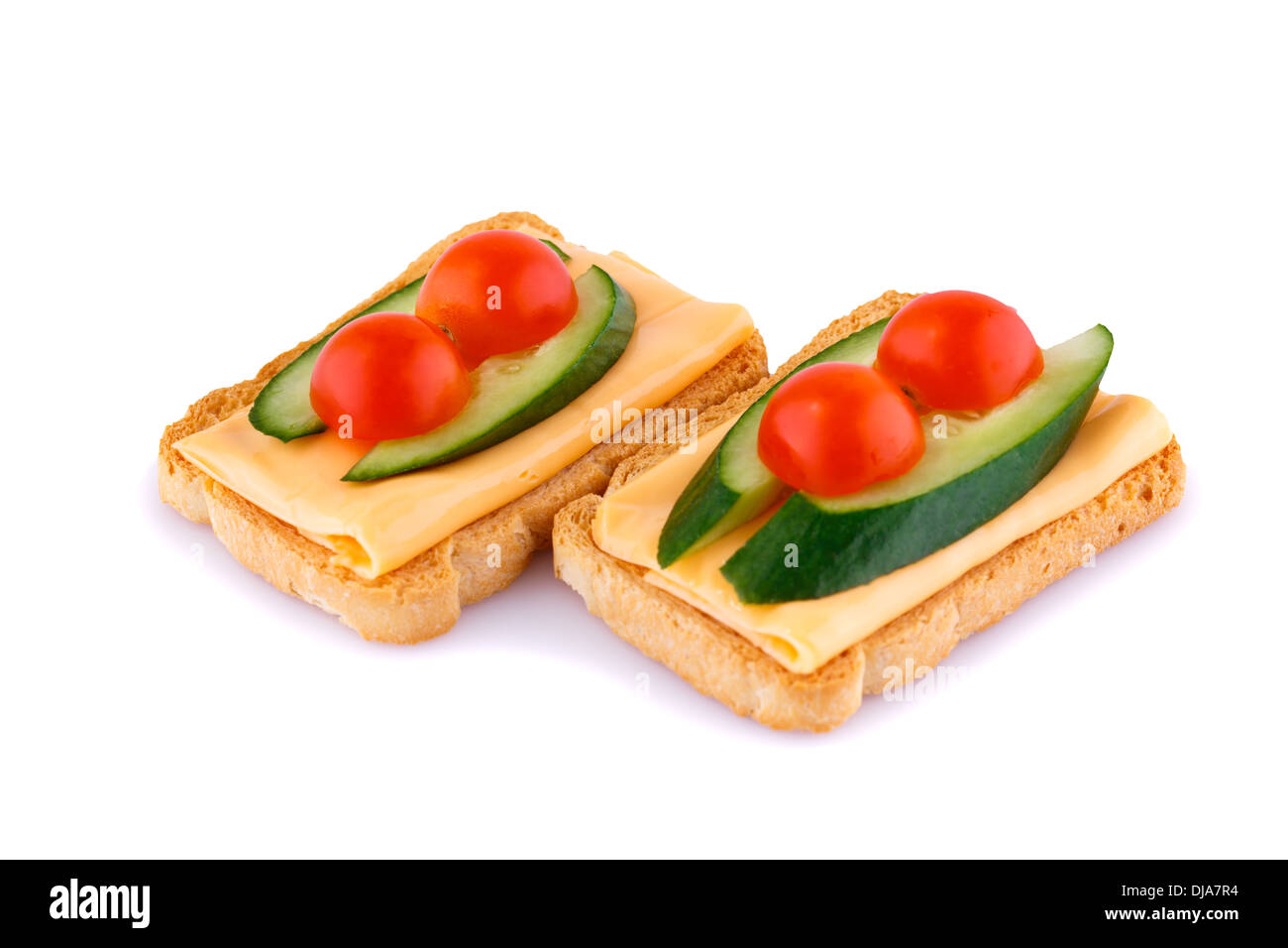 Rusk sandwiches with tomato, cucumber and cheese isolated on white background. Stock Photo