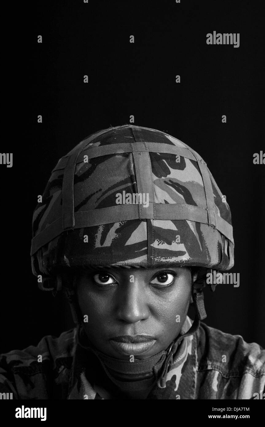 Black & white portrait of black female British solder against a black background. Stock Photo