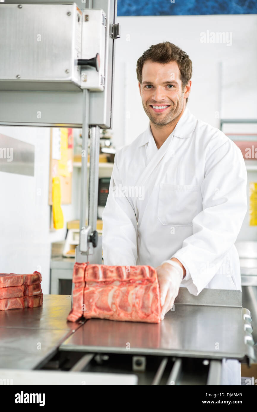 Butcher Slicing Meat On Bandsaw Stock Photo