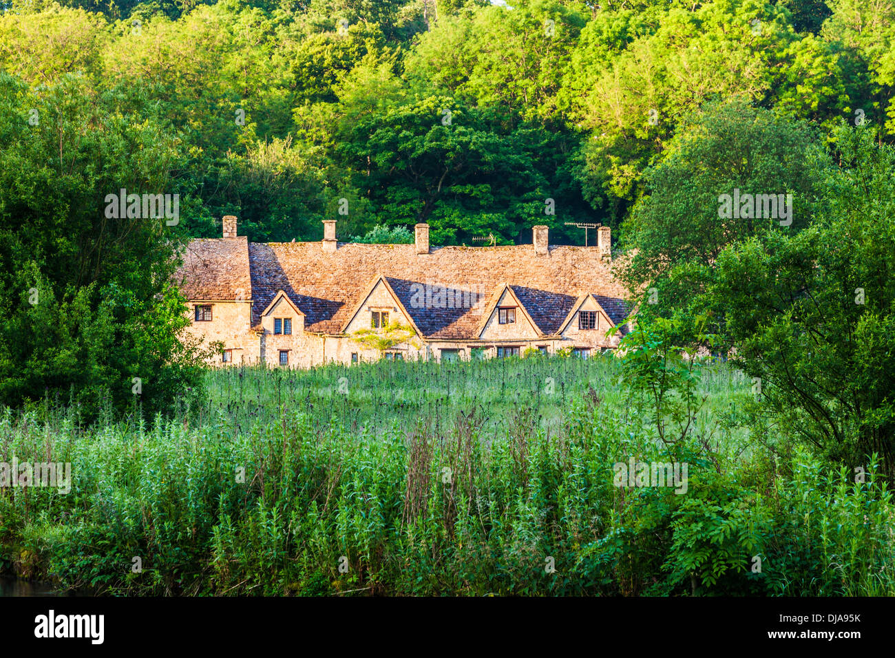 View over the Rack Isle water meadow to the famous Arlington Row cottages in the Cotswold village of Bibury. Stock Photo