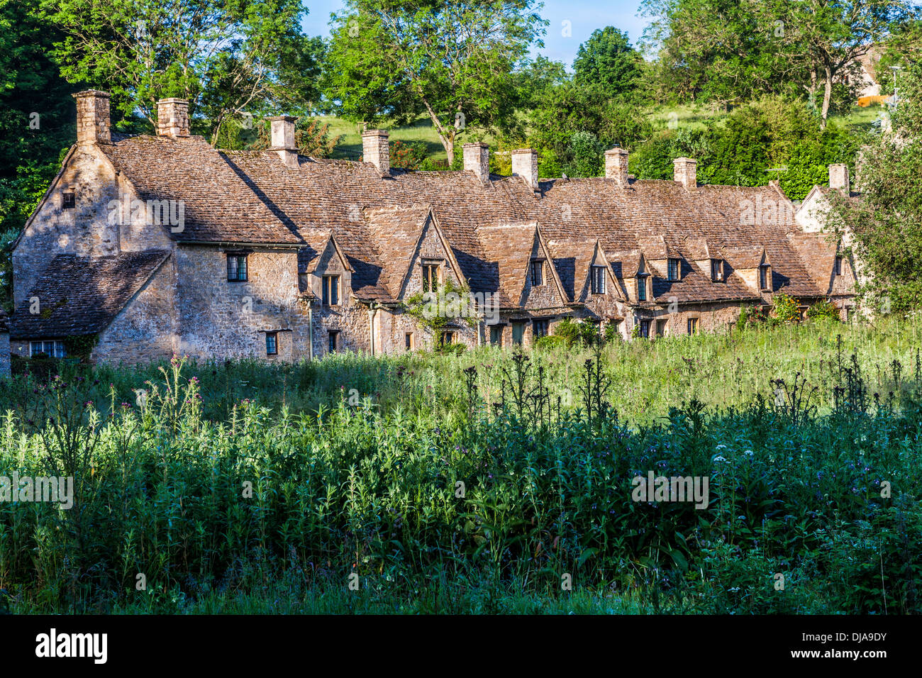 View over the Rack Isle water meadow to the famous Arlington Row cottages in the Cotswold village of Bibury. Stock Photo