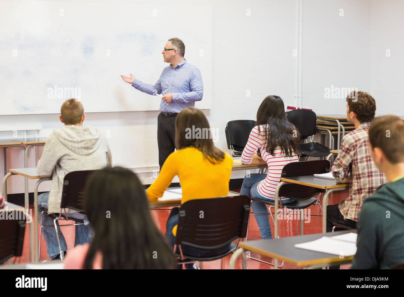 Attentive students with teacher in the classroom Stock Photo