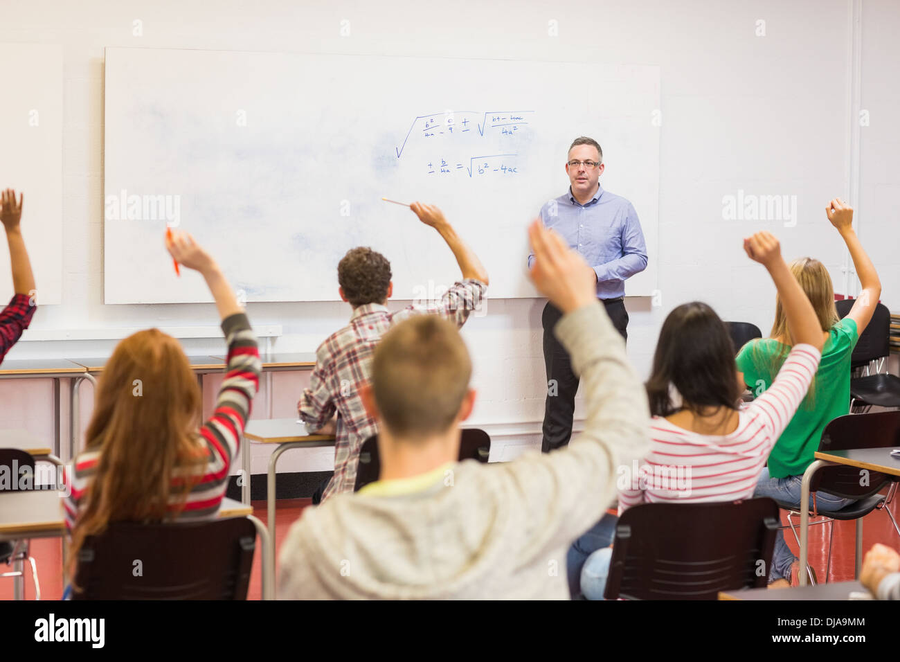 Students raising hands in the classroom Stock Photo