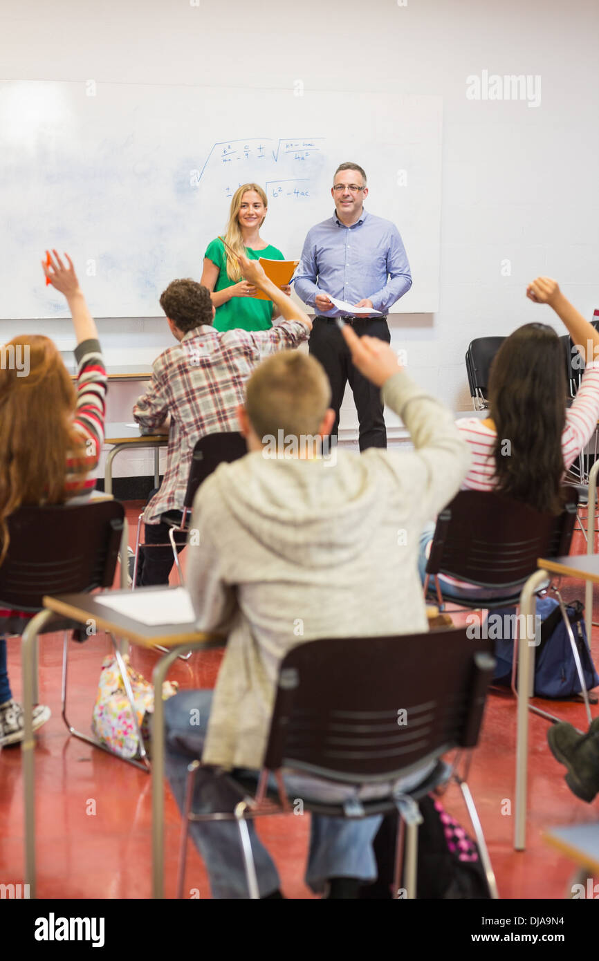 Students raising hands in the classroom Stock Photo