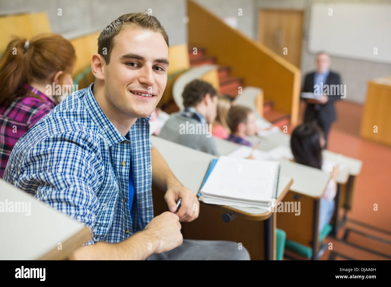 Smiling male with students and teacher at lecture hall Stock Photo