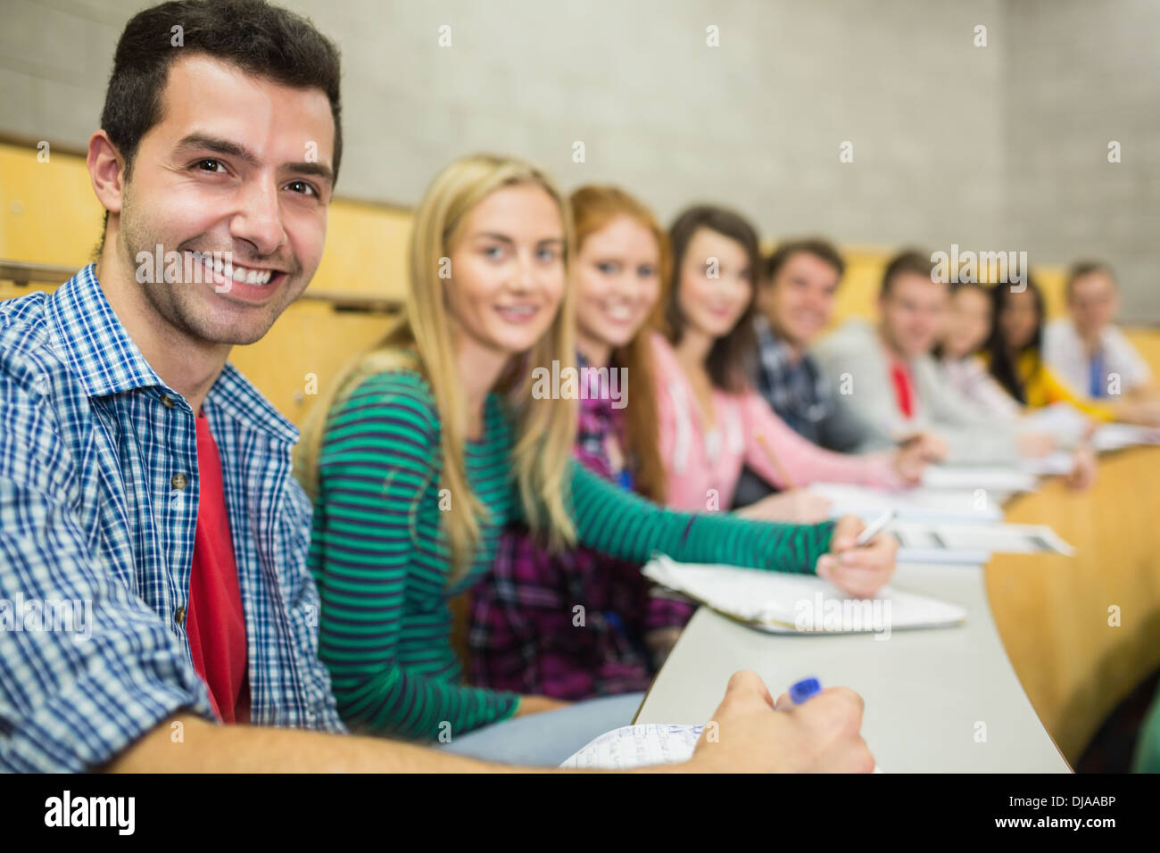 Smiling students in a row at the lecture hall Stock Photo