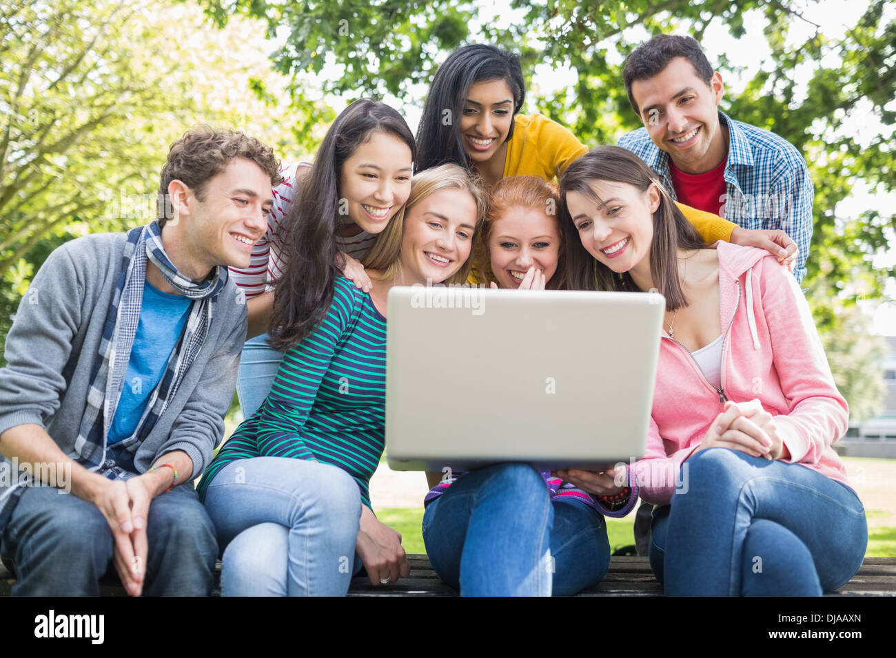 College students using laptop in park Stock Photo
