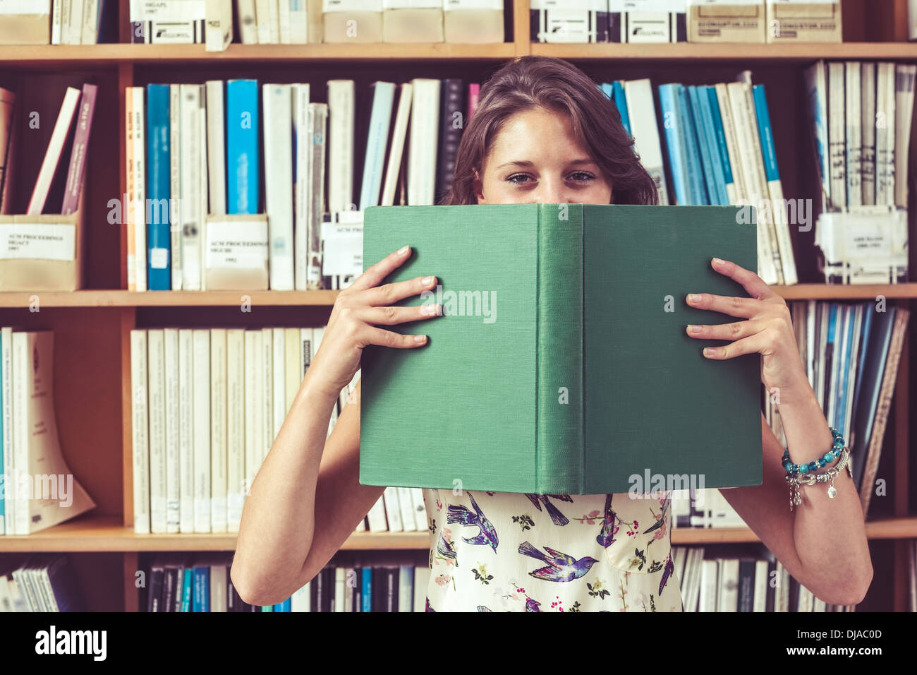 Woman holding book in front of face hi-res stock photography and images ...