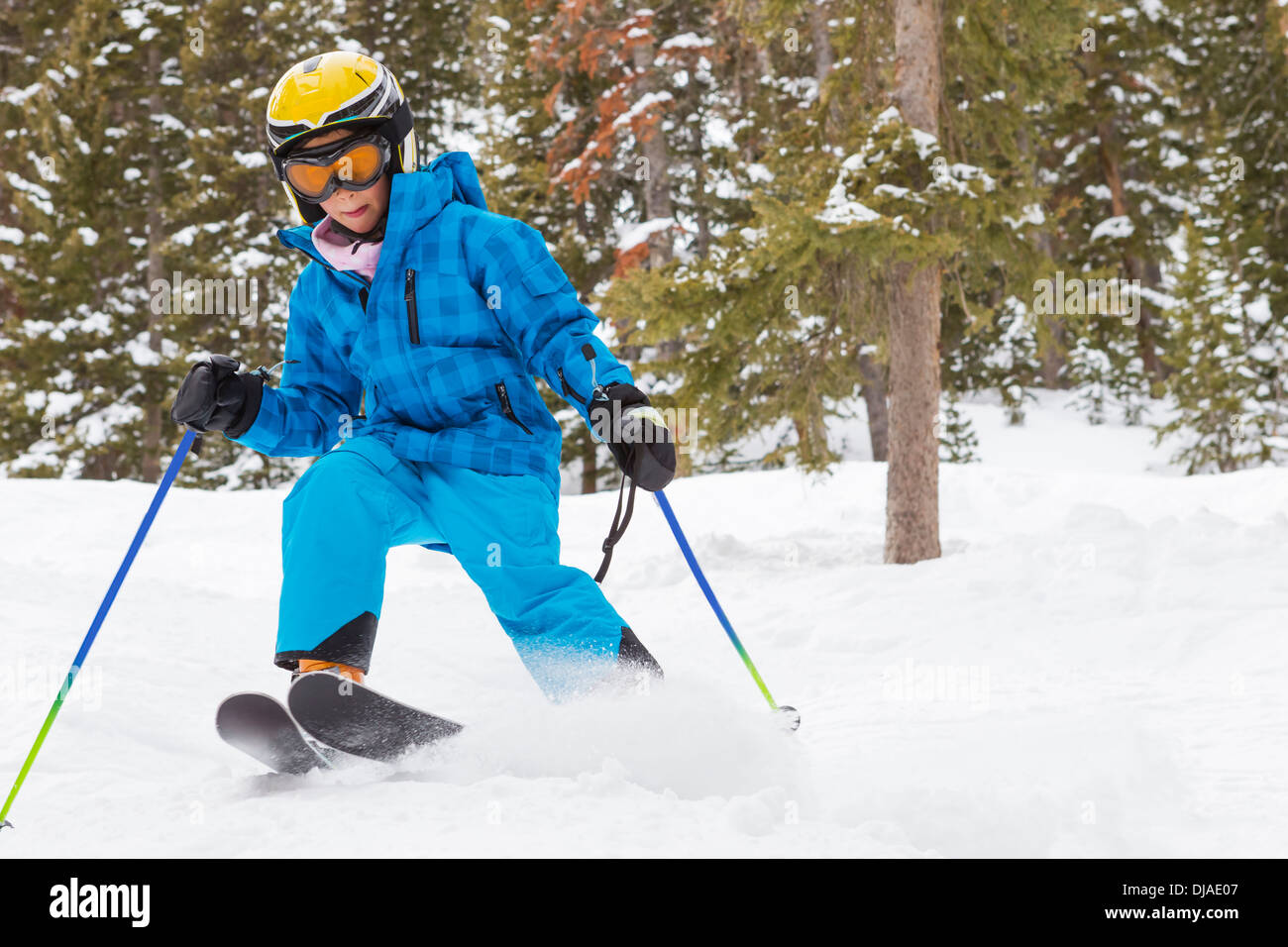 Mixed race girl skiing on snowy slope Stock Photo