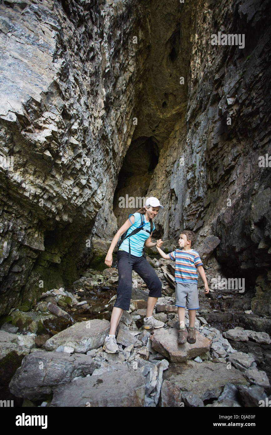 Caucasian mother and son exploring cave Stock Photo