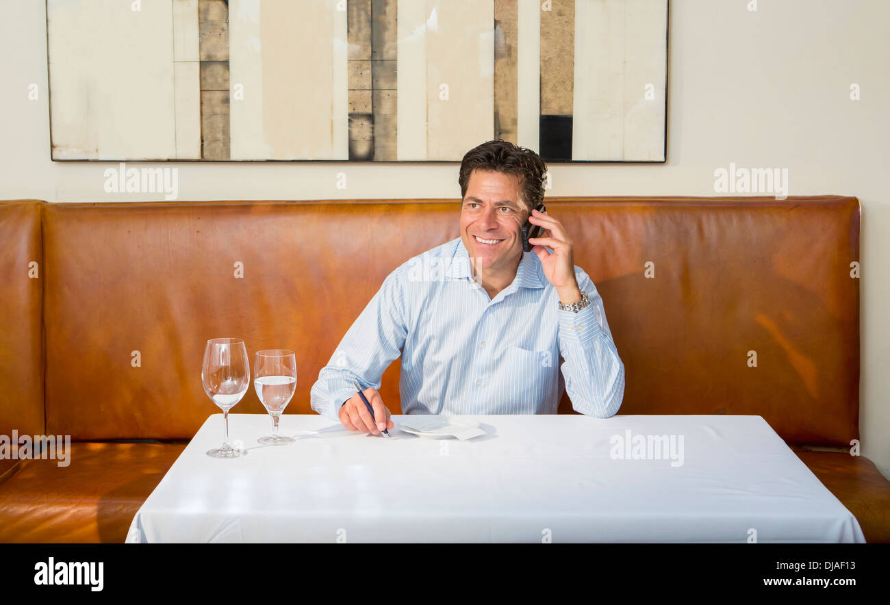 Caucasian businessman on cell phone at restaurant Stock Photo