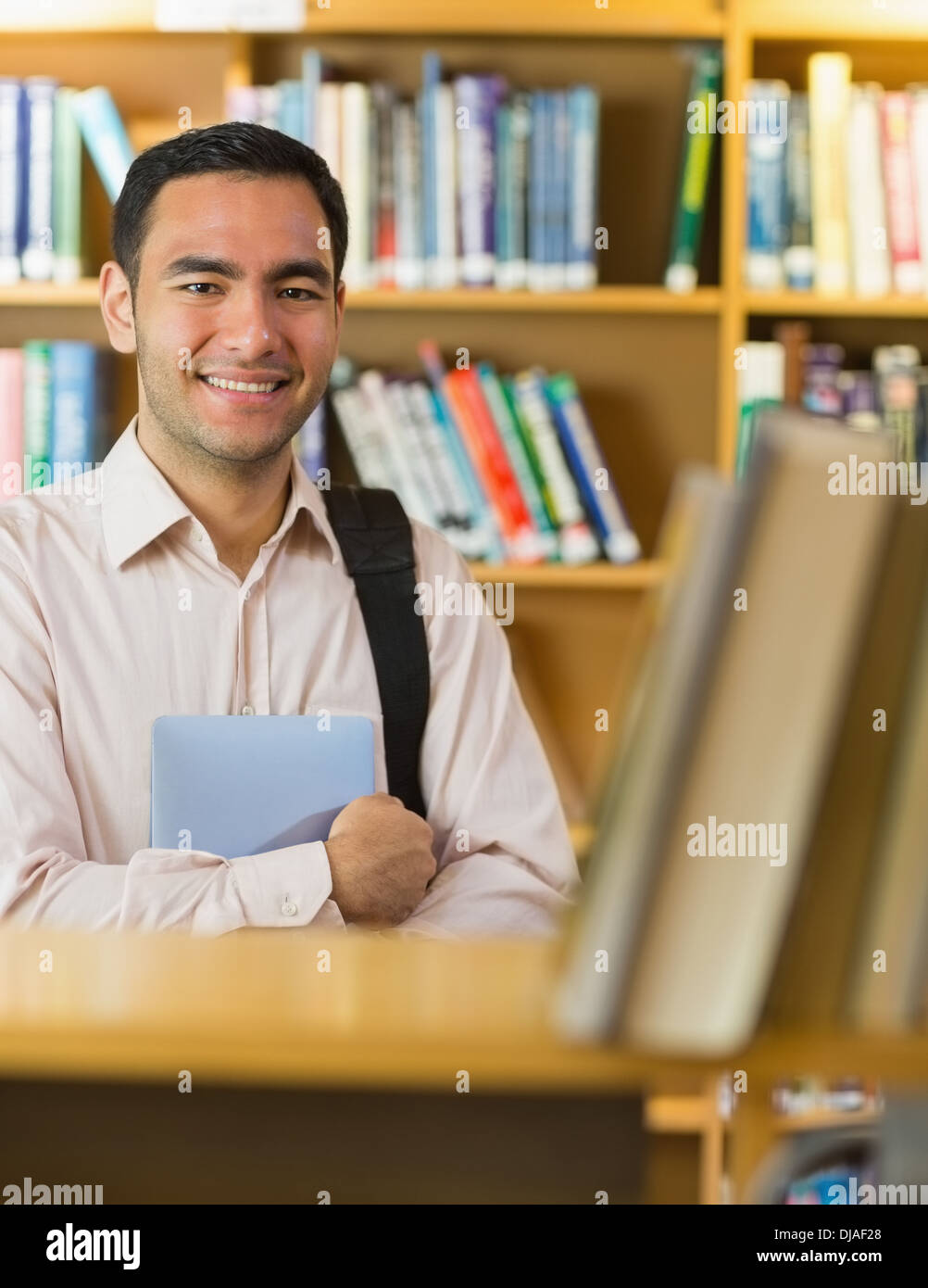 Smiling mature student with tablet PC in library Stock Photo