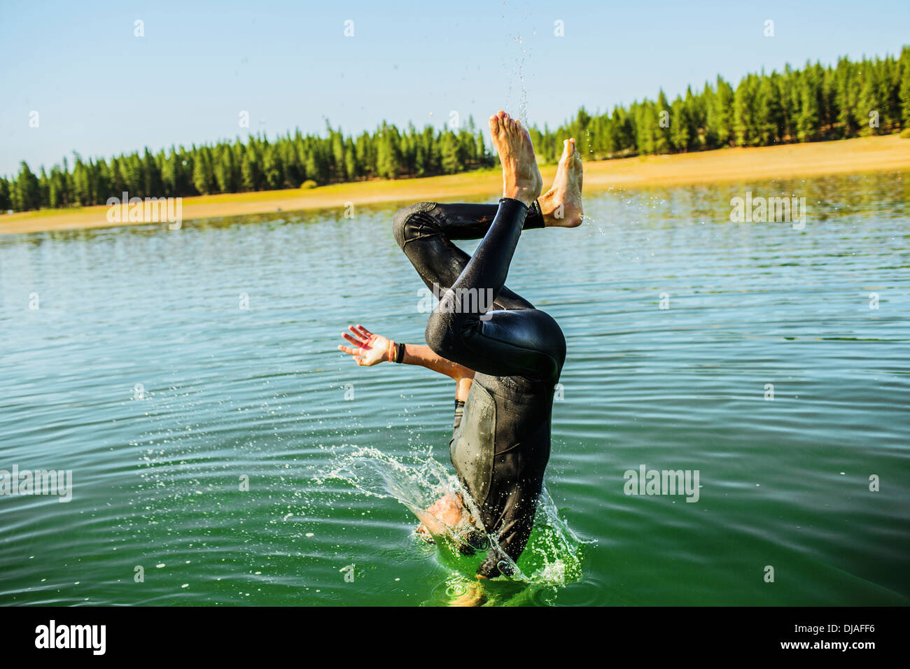 Caucasian man jumping into rural lake Stock Photo