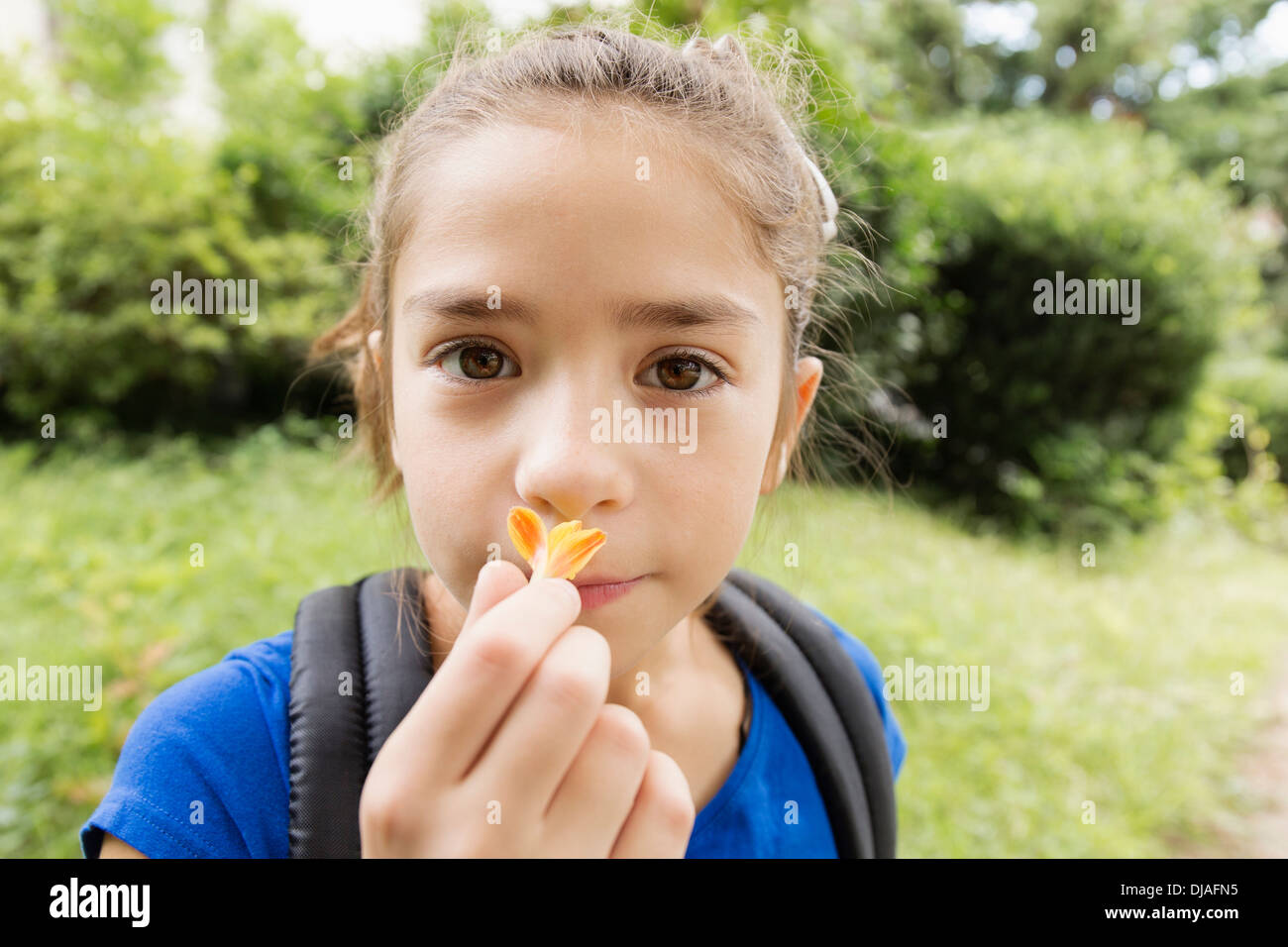 Mixed race girl smelling flower Stock Photo