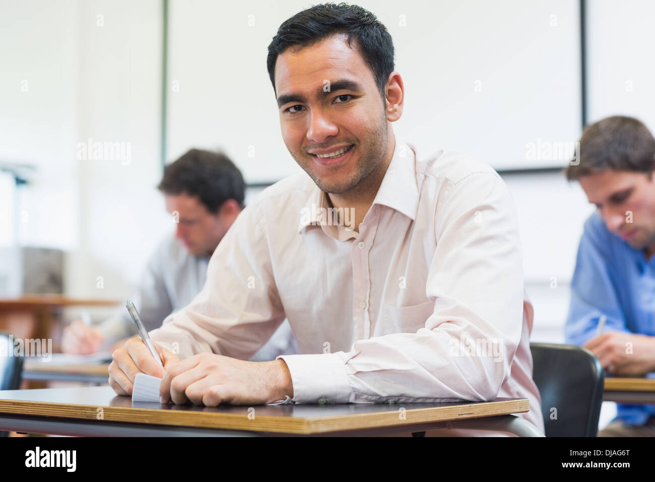 Mature students taking notes in classroom Stock Photo