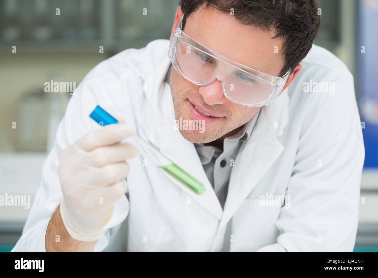 Scientist analyzing green solution in test tube at the lab Stock Photo ...