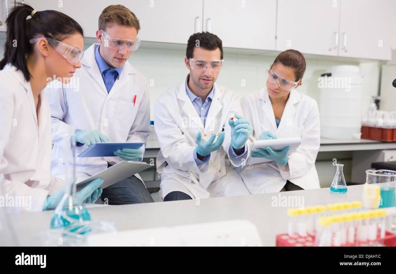 Scientists with tablet PC working on an experiment at lab Stock Photo