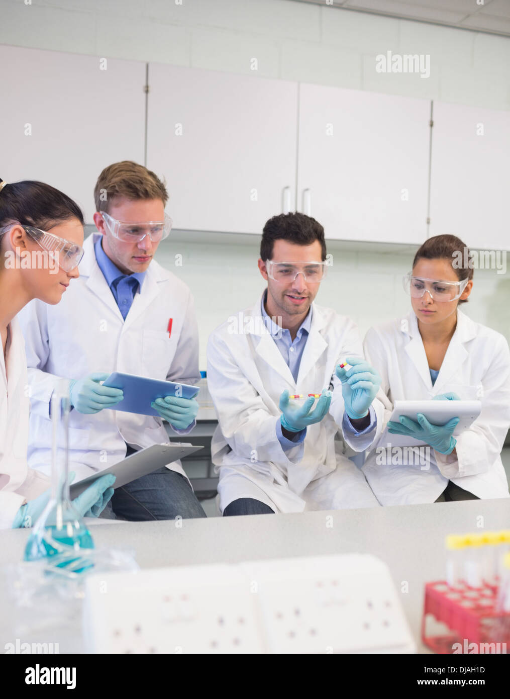 Scientists with tablet PC working on an experiment at lab Stock Photo