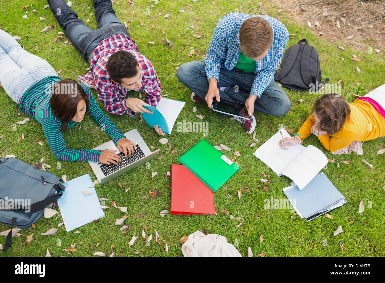 College students using laptop while doing homework in park Stock Photo