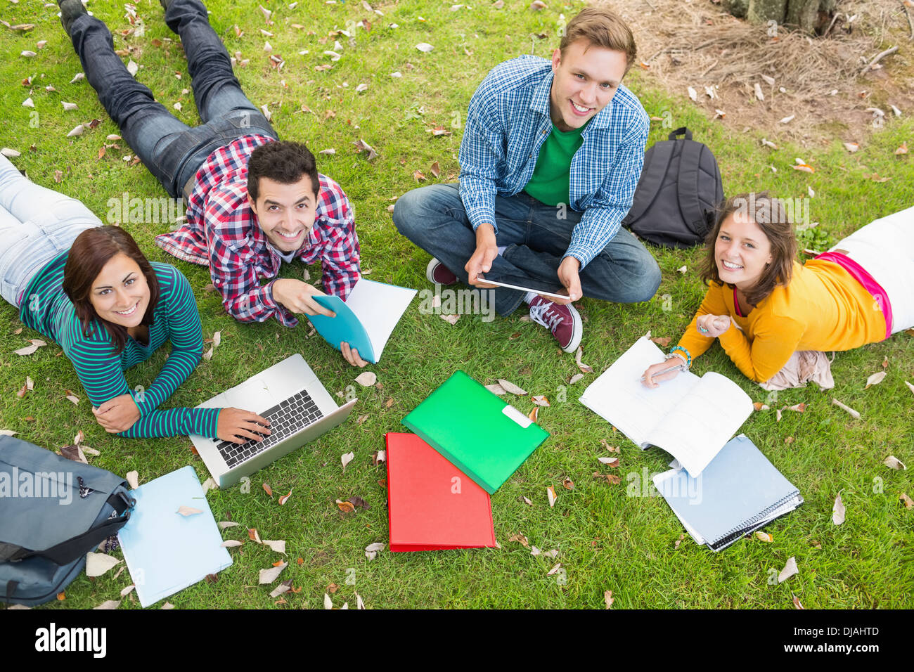 College students using laptop while doing homework in park Stock Photo