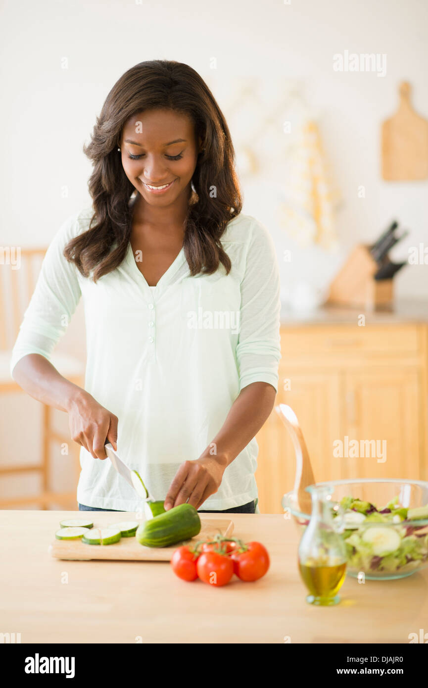 Black woman chopping vegetables in kitchen Stock Photo