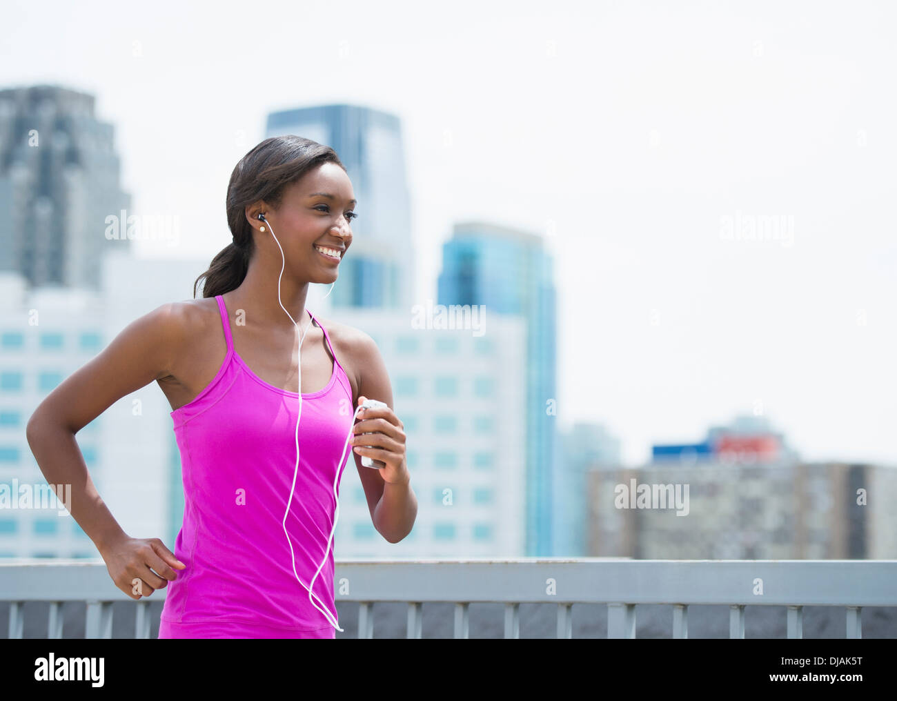 Black woman running on city street Stock Photo