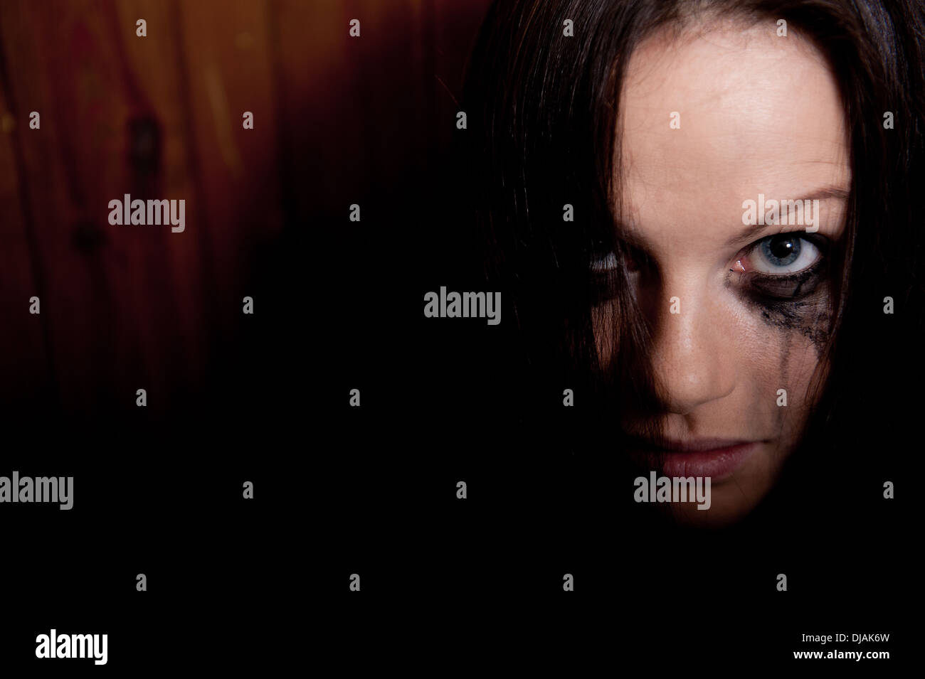 Tearful young woman with her make-up running down her face. Stock Photo