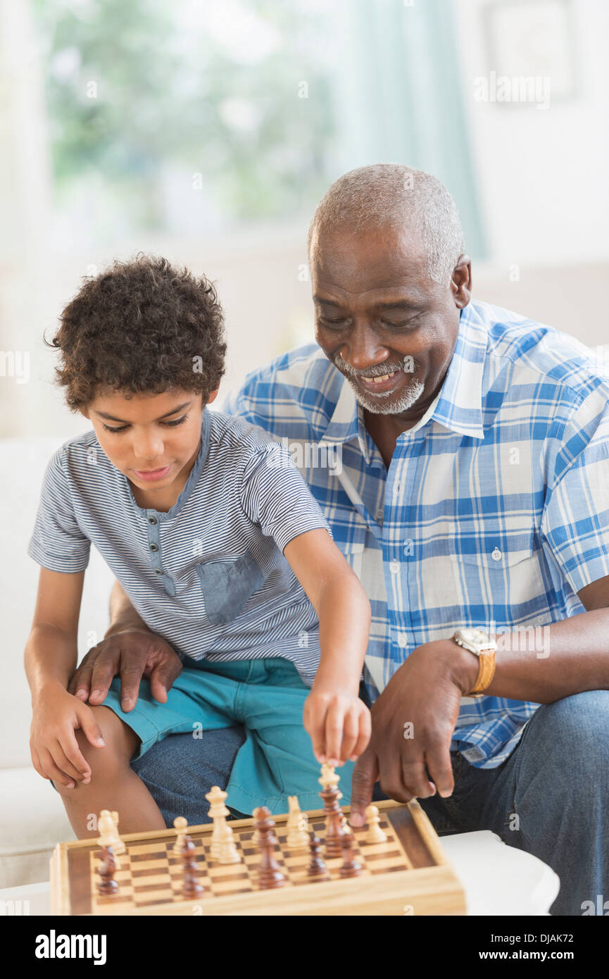 Boy playing chess with grandfather Stock Photo