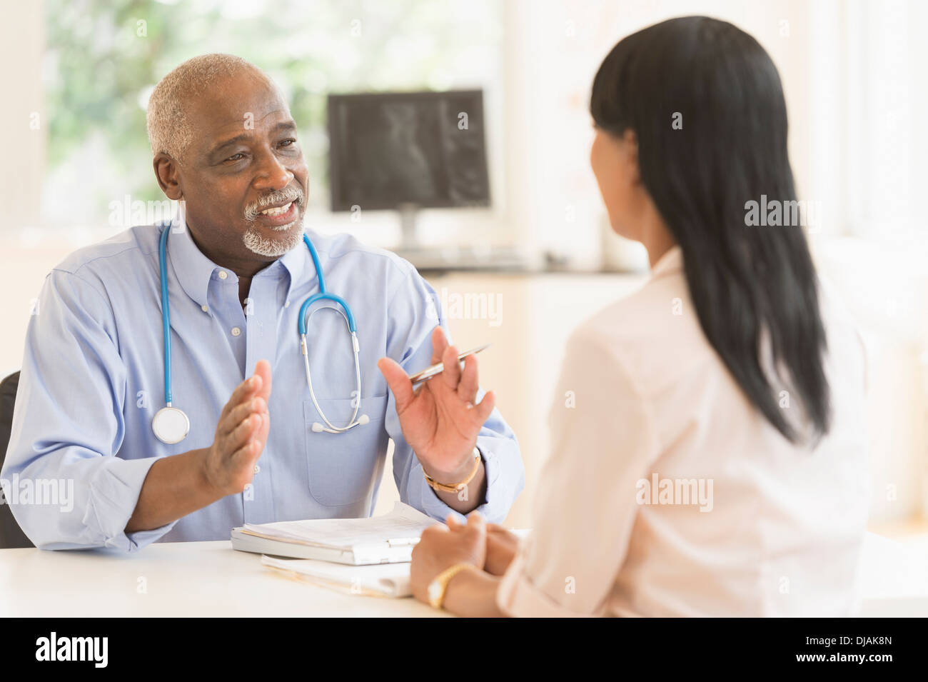 Black doctor and patient talking in office Stock Photo