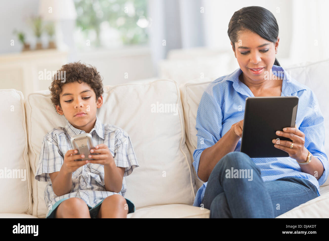 Mother and son relaxing on sofa Stock Photo