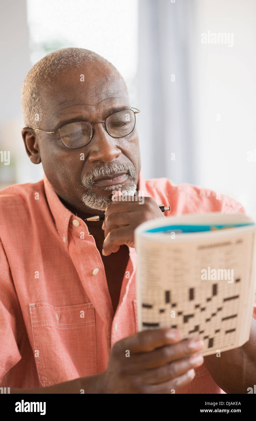 Black man doing crossword puzzle Stock Photo