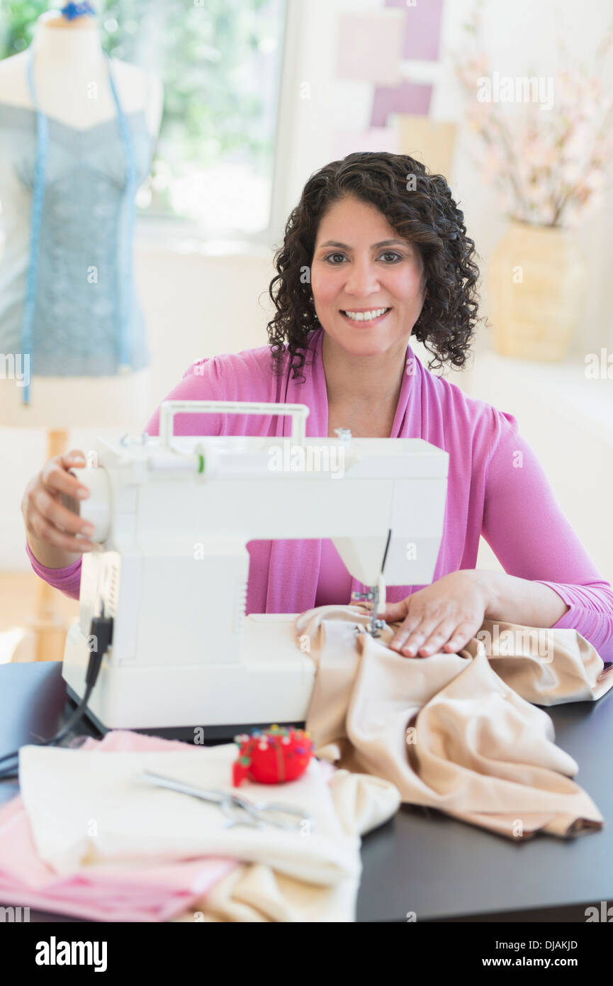 Hispanic dressmaker working at sewing machine Stock Photo