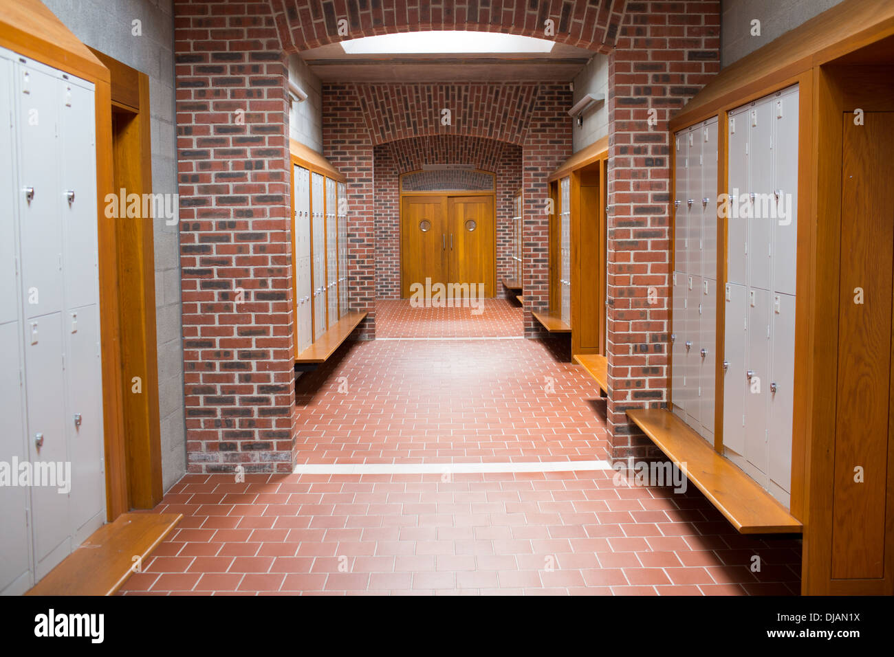 Brick walled corridor with tiled flooring in college Stock Photo