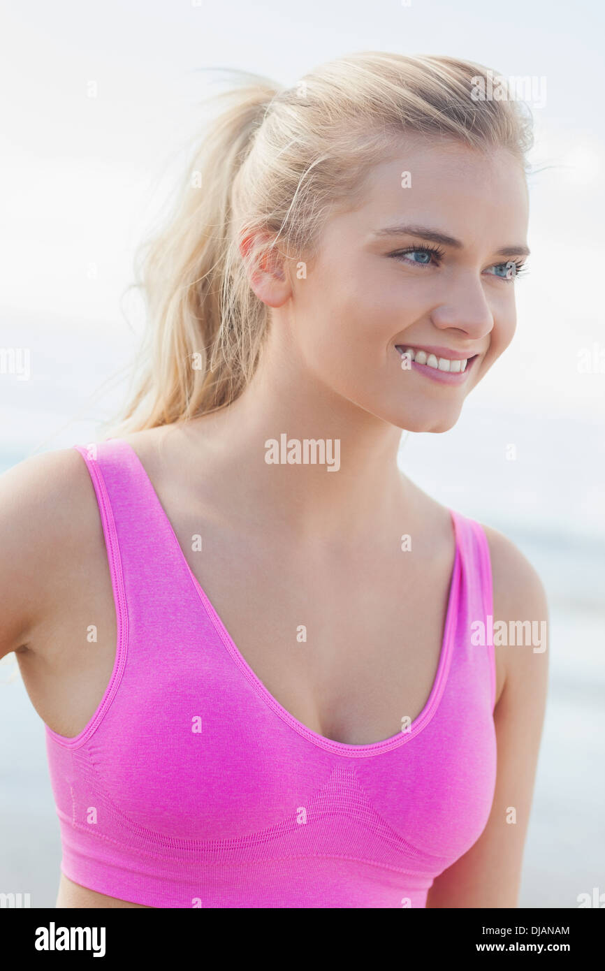Side view of confident young ethnic lady in sports bra waving American flag  and looking at camera against modern glass skyscraper Stock Photo - Alamy
