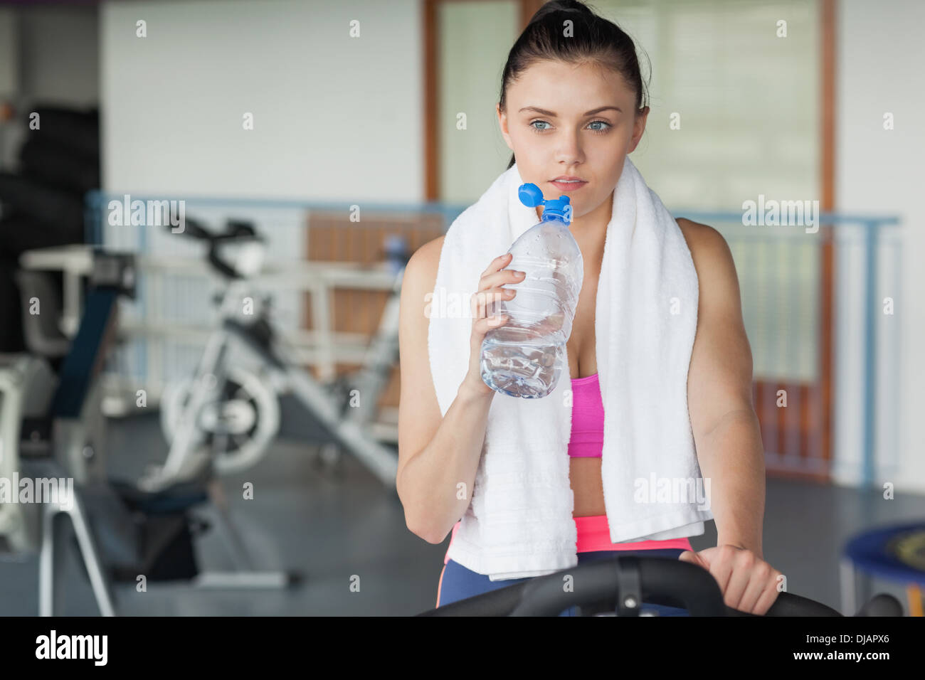 Woman drinking water while working out at spinning class Stock Photo