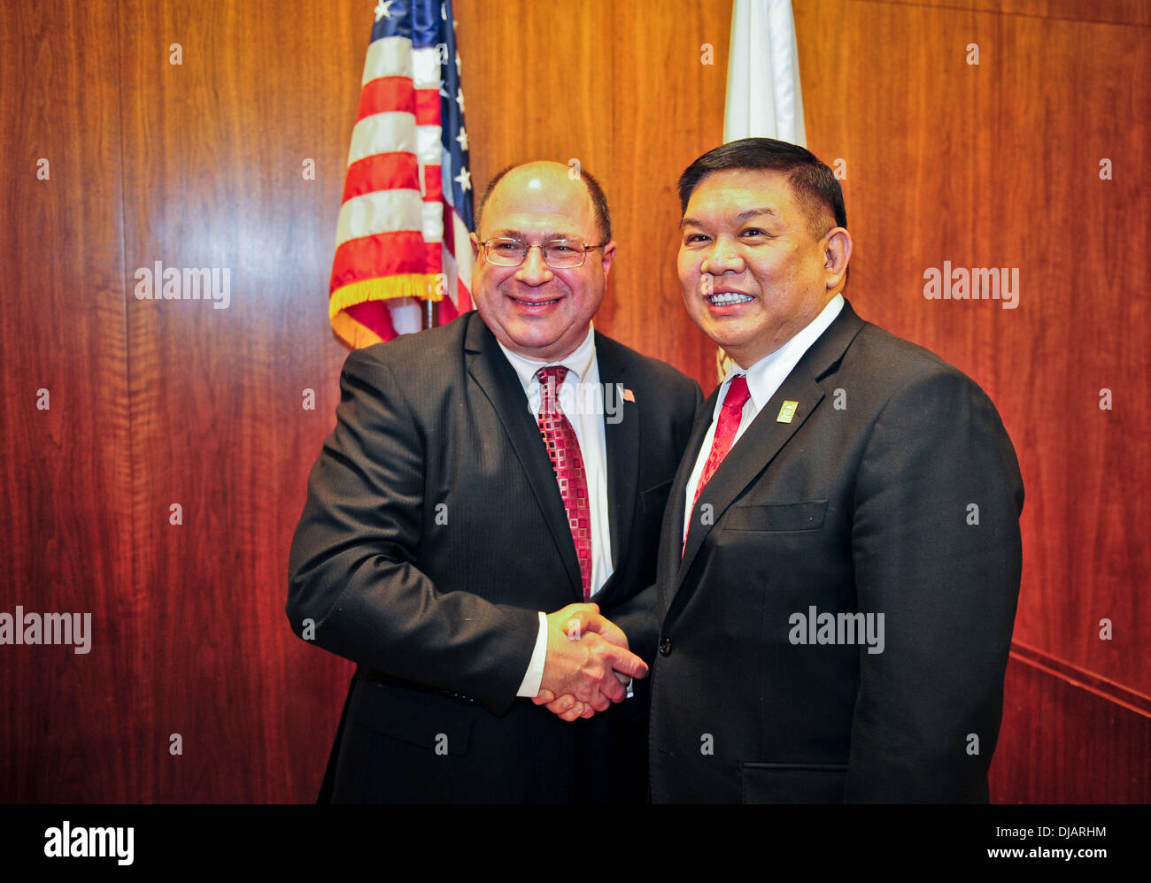 Alhambra, California. 25th Nov, 2013. Stephen K. Sham, the newly elected mayor of Alhambra, California, shakes hands with former mayor Steven T. Placido at a handover ceremony in Alhambra, California, Nov. 25, 2013. Sham, a descendant from Chaoshan, China, became the first Asian American mayor of Alhambra in 2006 since Alhambra was founded in 1903. Credit:  Zhang Chaoqun/Xinhua/Alamy Live News Stock Photo