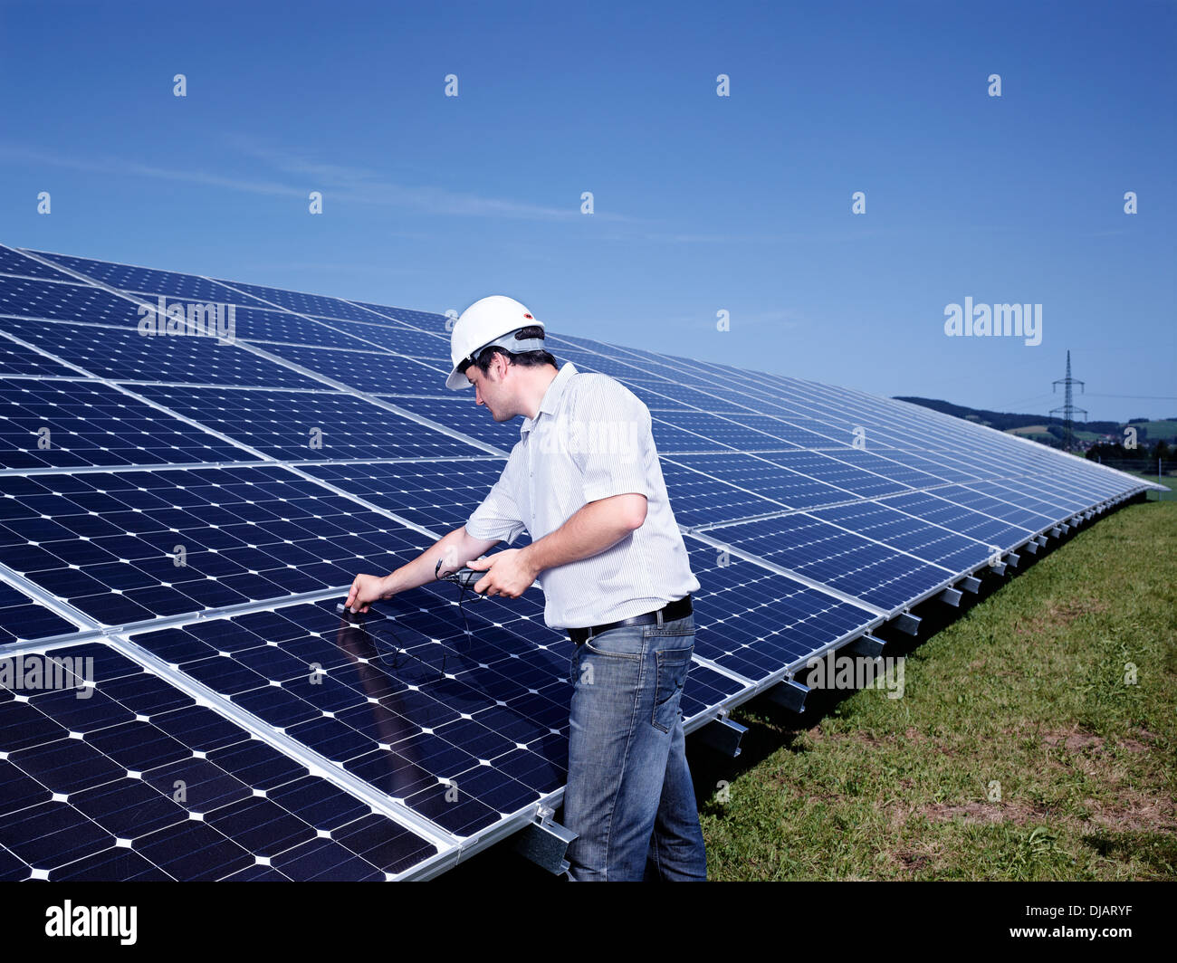 Solar installation technician checking solar panels with a measuring