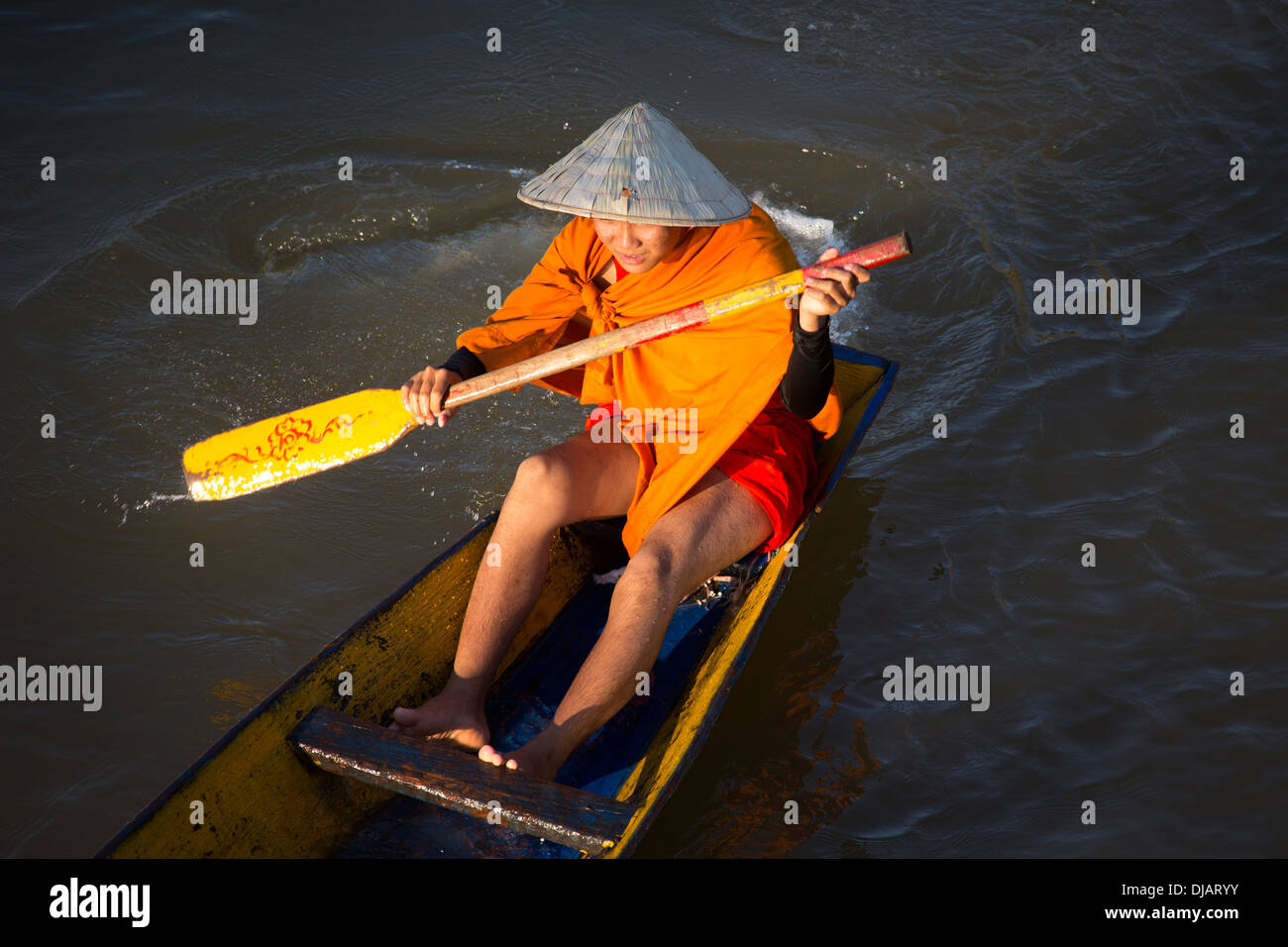 Buddhist monks on a row boat on the Mekong River in Paske, Laos Stock Photo