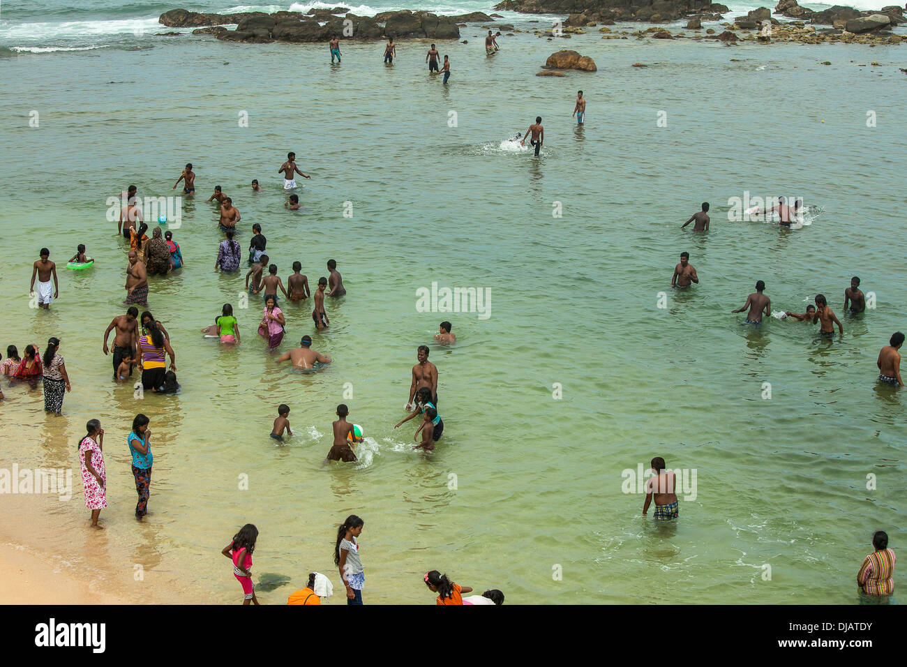 Sri Lankan people relaxing and swimming in the ocean Stock Photo