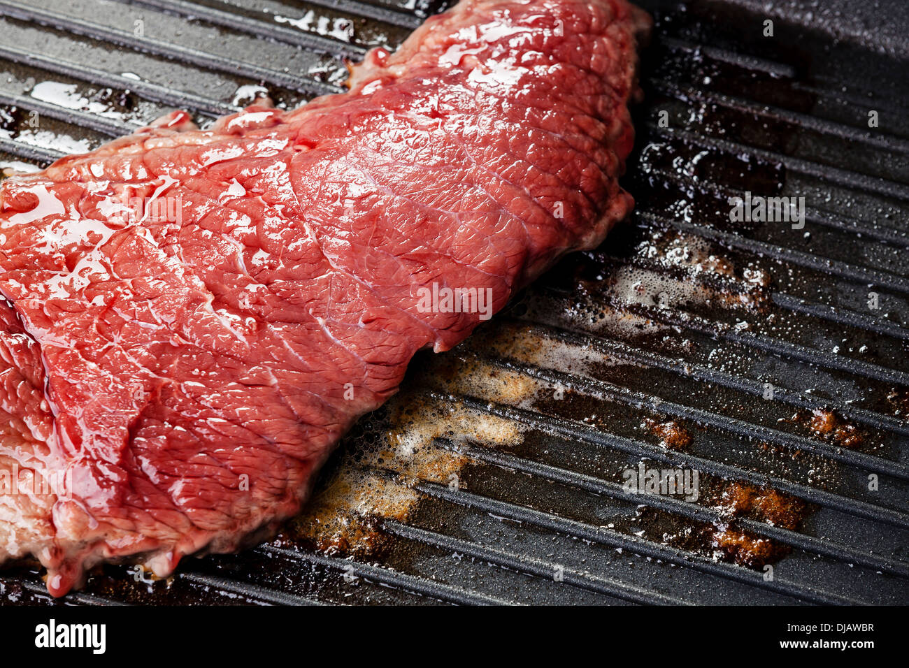 Bloody beef steak on grill pan background Stock Photo