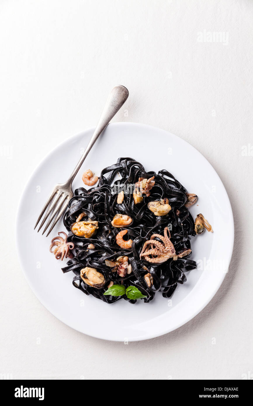 Black pasta with seafood on white plate Stock Photo