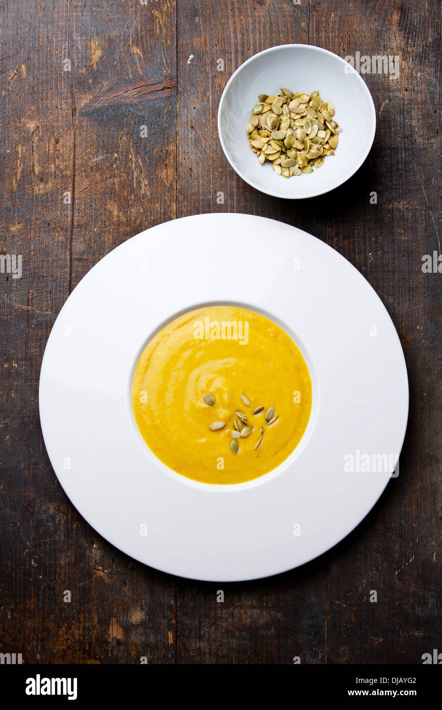 Pumpkin soup with pumpkin Seeds on wooden background Stock Photo