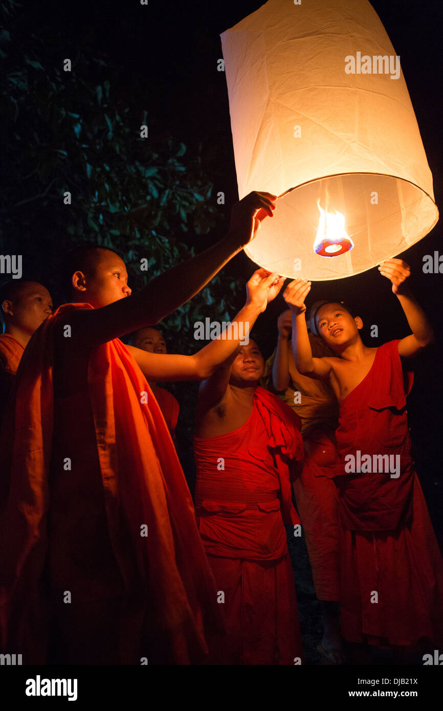 Buddhist monks lighting Chinese sky lanterns in Paske, Laos Stock Photo