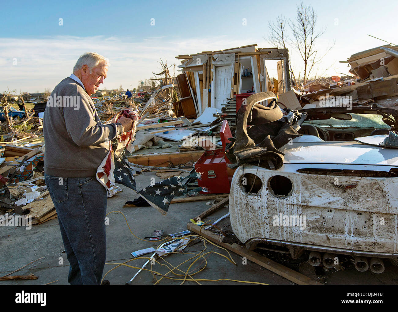 A resident recovers an American flag from his home destroyed by an EF-4 tornado November 19, 2013 in Washington, IL. The tornado left a path of destruction that stretched for more than 46 miles and damaged fourteen-hundred homes. Stock Photo