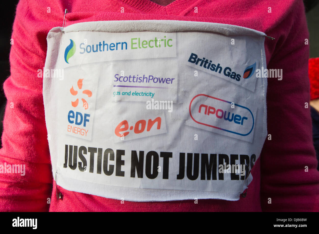 London, UK. 26 November 2013. Picture: a protester wears a 'Justice not Jumpers' sign. Protesters gathered in the City of London to demonstrate against the Government's fuel policy for pensioners and the price hikes of the Bix Six energy companies (Southern Electric, British Gas, EDF, Electricité de France, E.ON, Scottish Power, RWE npower). Photo: Nick Savage/Alamy Live News Stock Photo