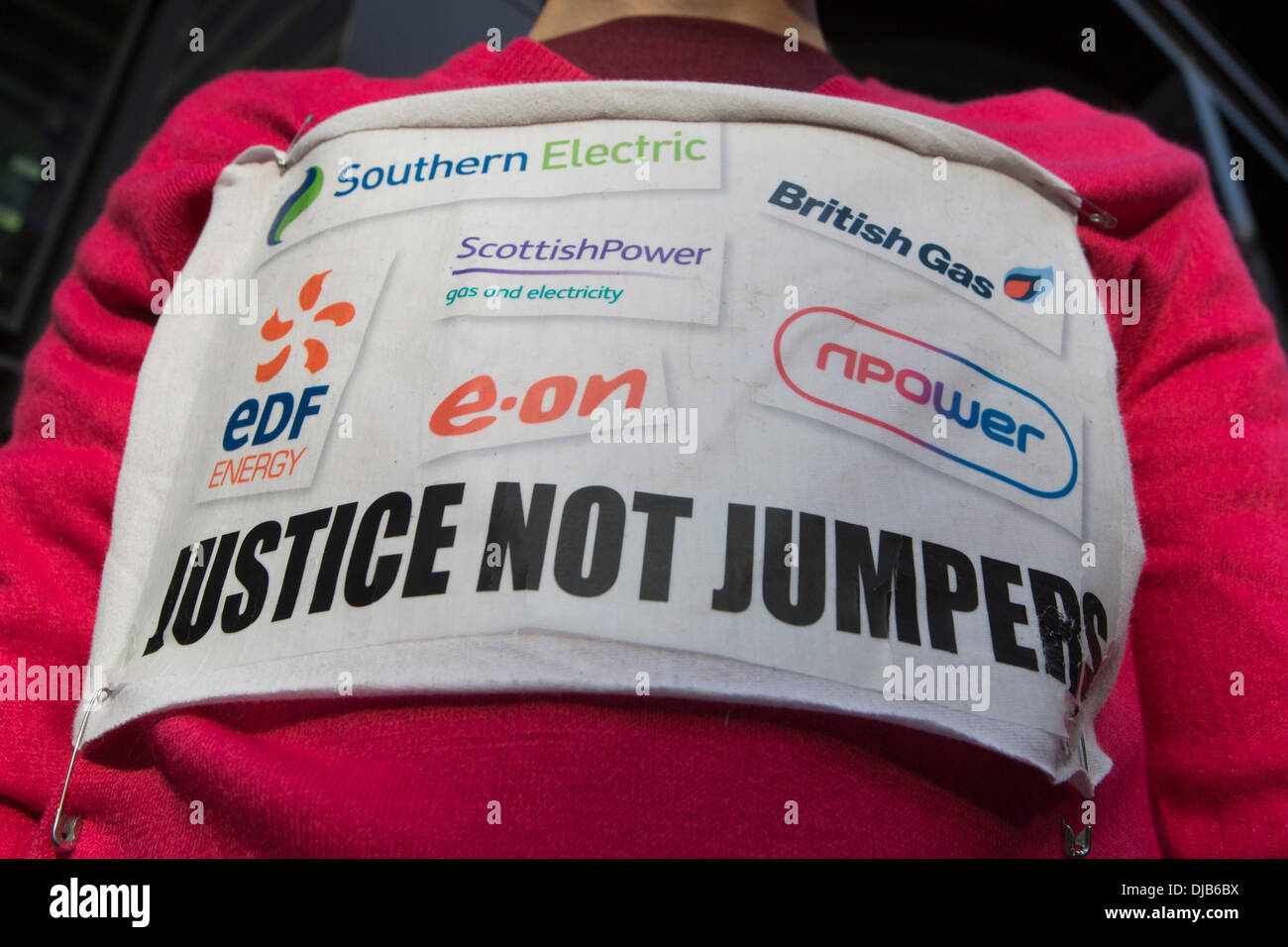 London, UK. 26 November 2013. Picture: a protester wears a 'Justice not Jumpers' sign. Protesters gathered in the City of London to demonstrate against the Government's fuel policy for pensioners and the price hikes of the Bix Six energy companies (Southern Electric, British Gas, EDF, Electricité de France, E.ON, Scottish Power, RWE npower). Photo: Nick Savage/Alamy Live News Stock Photo