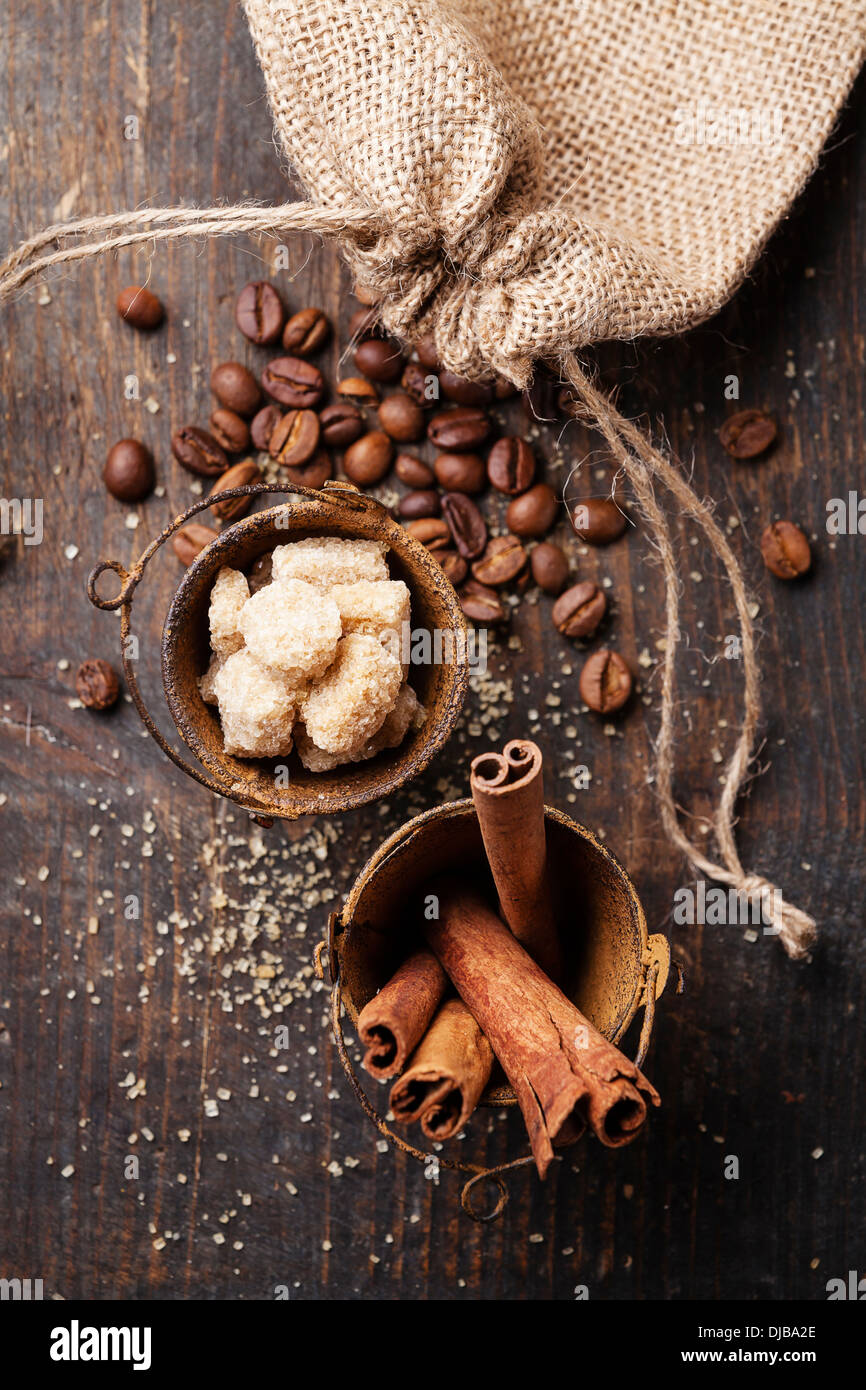 Cinnamon sticks, cane sugar and coffee beans on wooden background Stock Photo