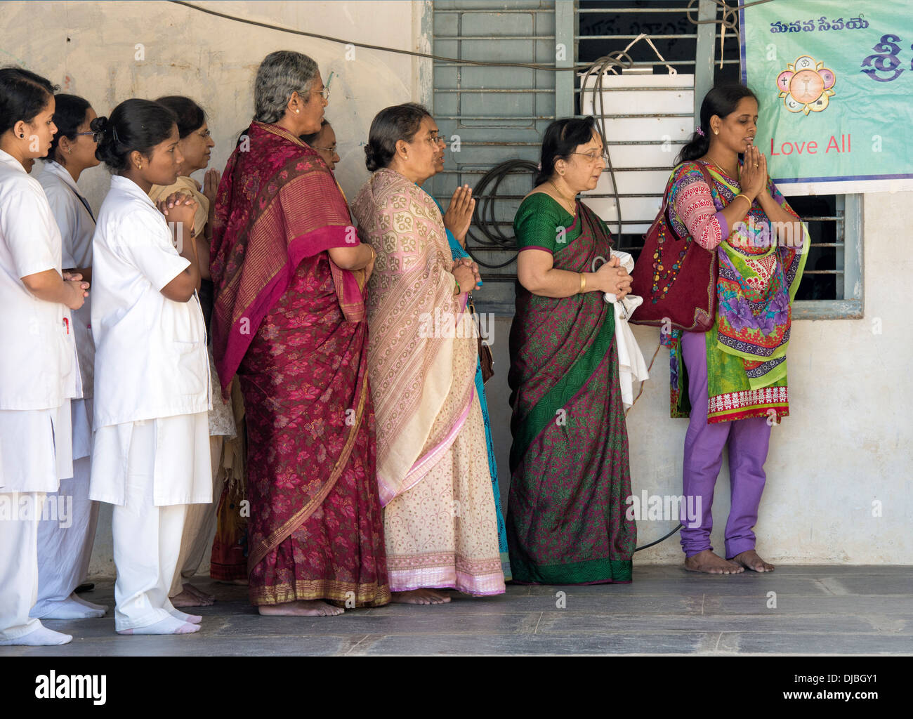Indian doctors and student nurses offer morning prayers at Sri Sathya Sai Baba mobile outreach hospital. Andhra Pradesh, India Stock Photo