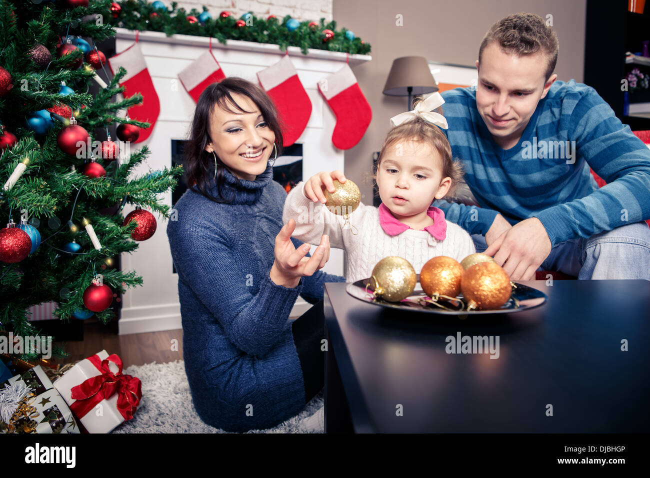 young family in front of christmas tree Stock Photo